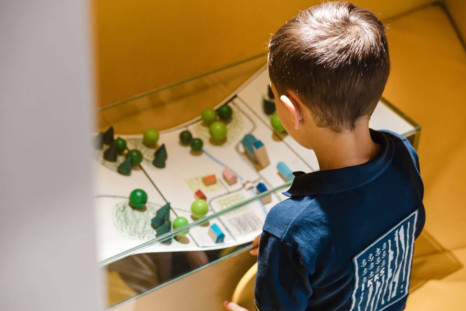 Enfant qui regarde une manipulation interactive dans l'expo archi chouette du sparkoh