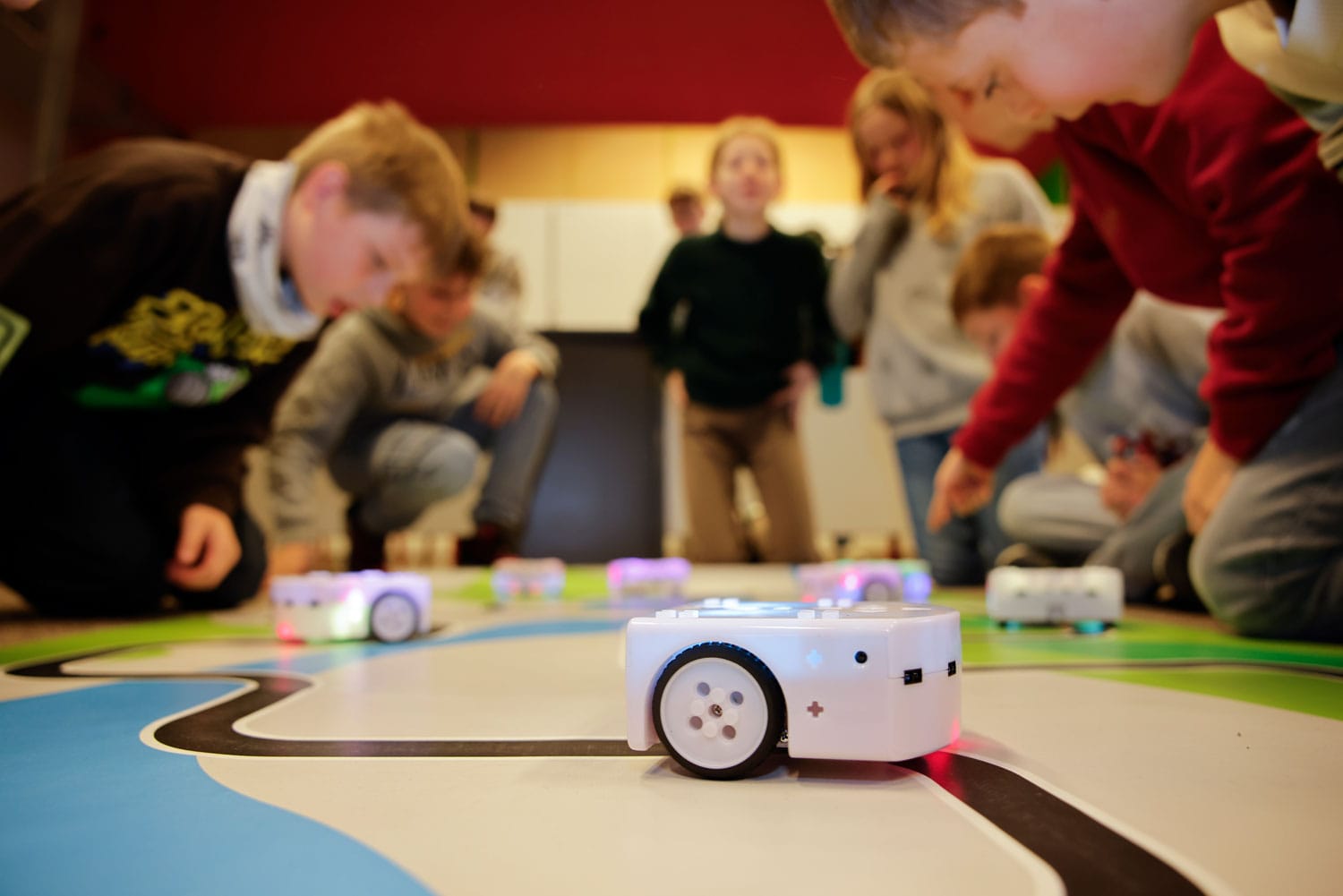 Gros plan sur robot THYMIO avec élèves en arrière plan flouté