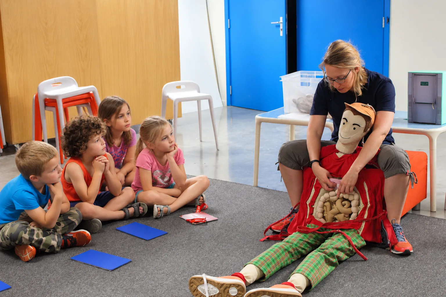 Enfants qui observent une poupée géante avec le ventre ouvert pour activité scientifique