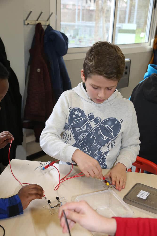 Garçon de primaire dans un atelier autour de l'électricité