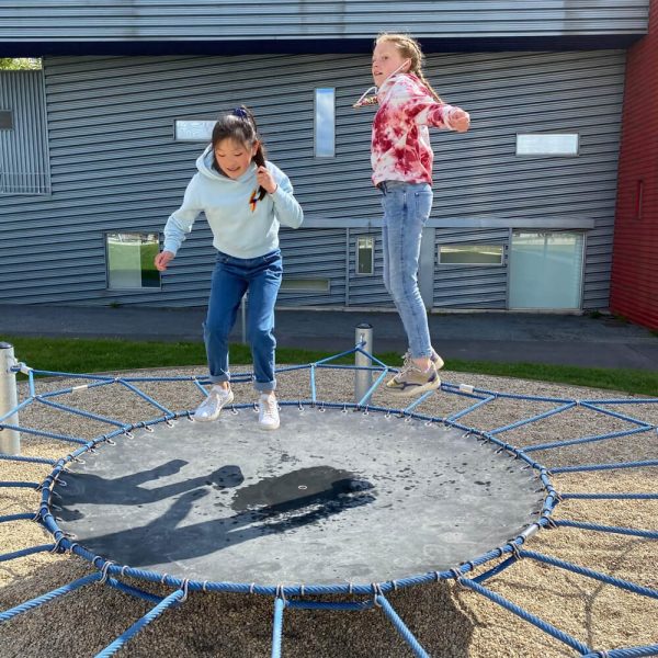 2 filles sautent sur un trampoline extérieur