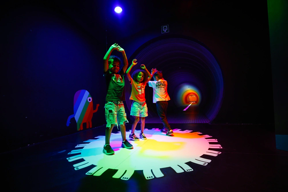 Enfants dansant dans l'expo Lumière