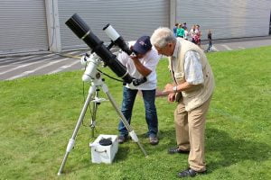 Senior et astronome autour d'un télescope