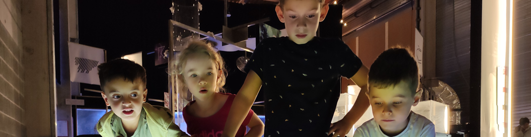 Enfants dans l'espace géodynamic qui regardent un volcan en videomapping