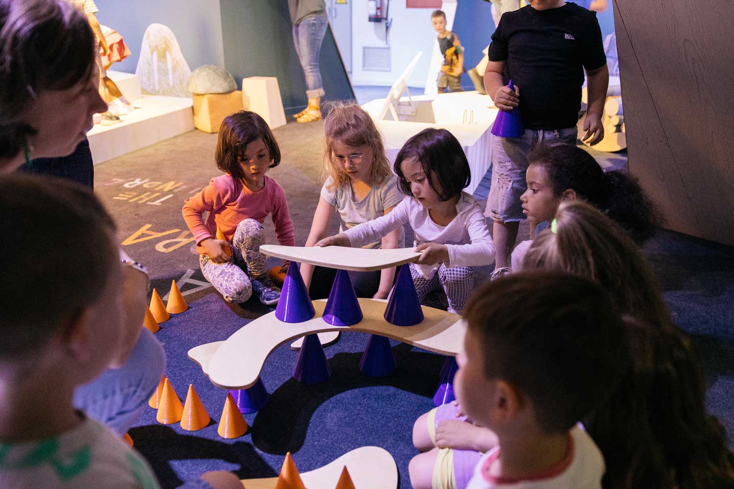 PLusieurs enfants essayent de faire tenir des formes en équilibre