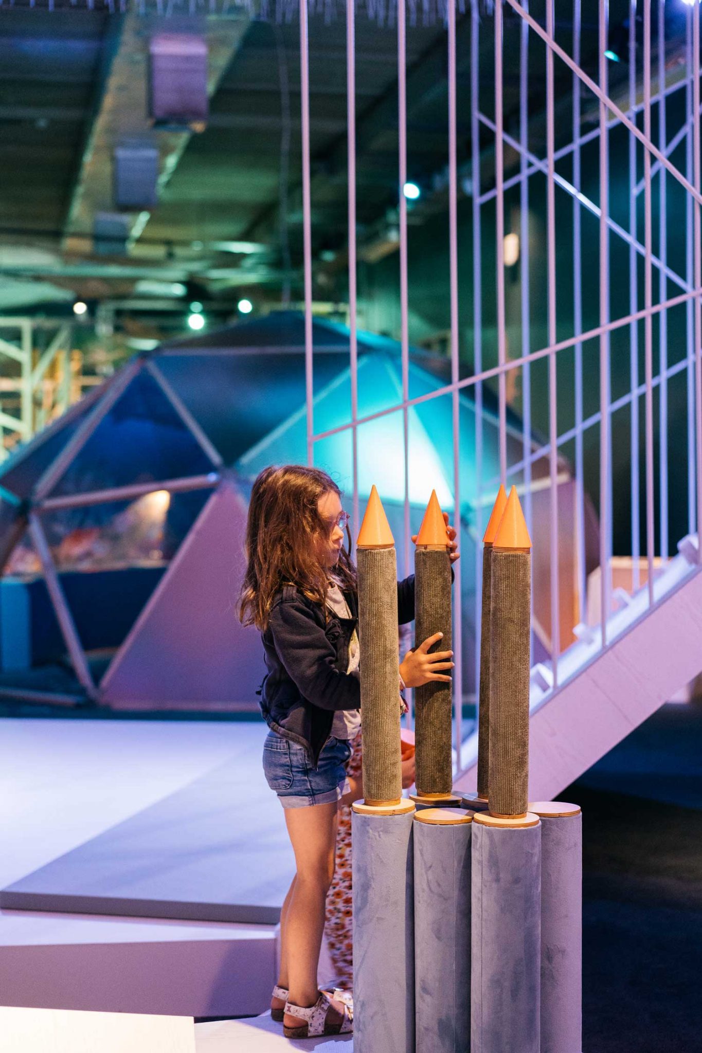 Fillette qui fait une tour avec des rondins en bois