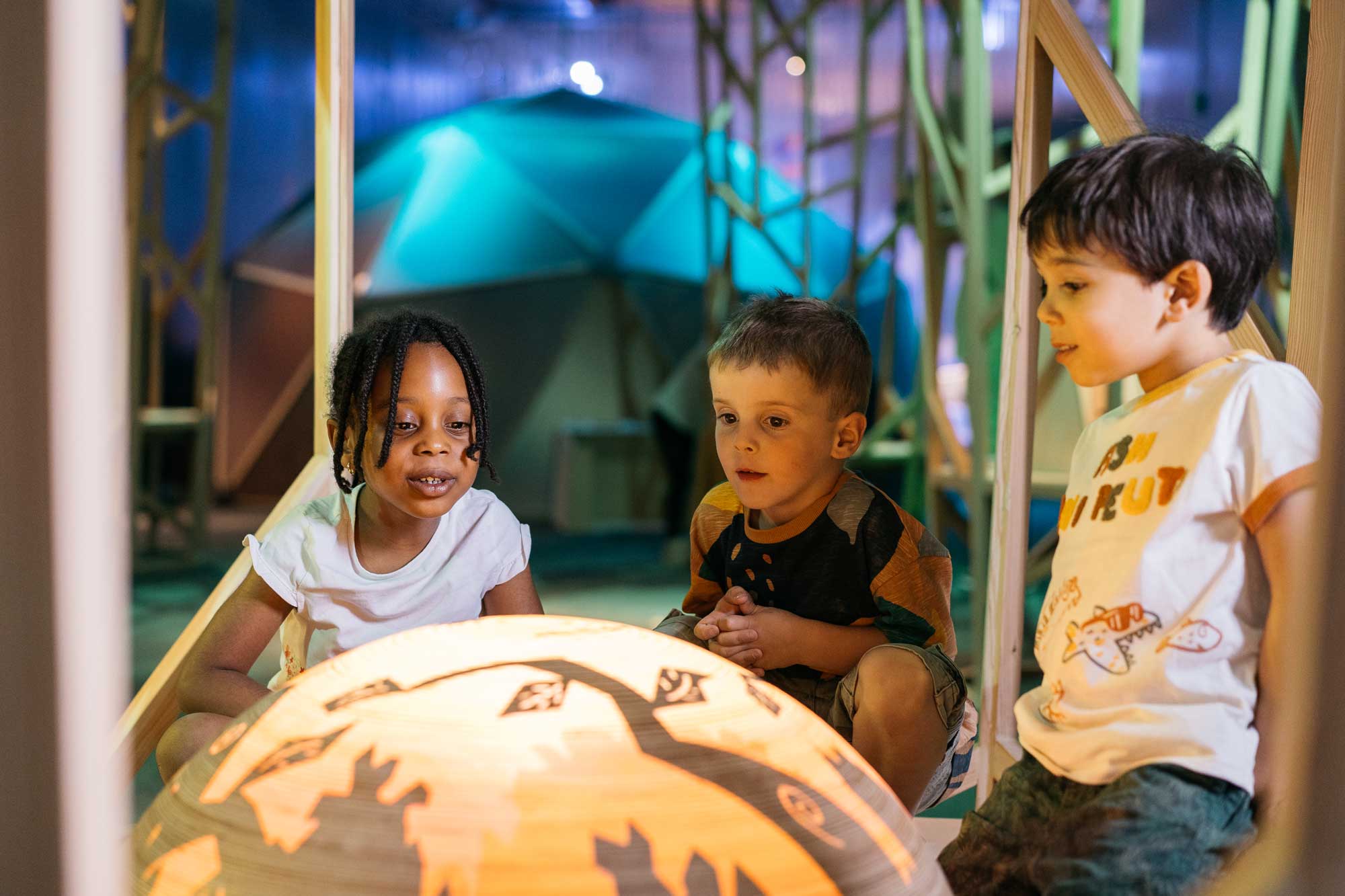 3 enfants écoutent un conte dans une exposition